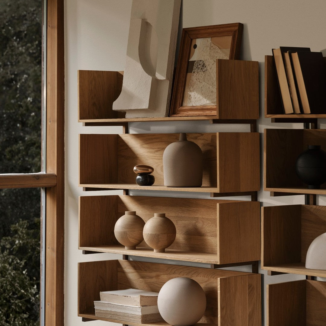 Warm wooden shelves featuring natural tones and smooth ceramic vases in neutral shades, creating an earthy aesthetic.