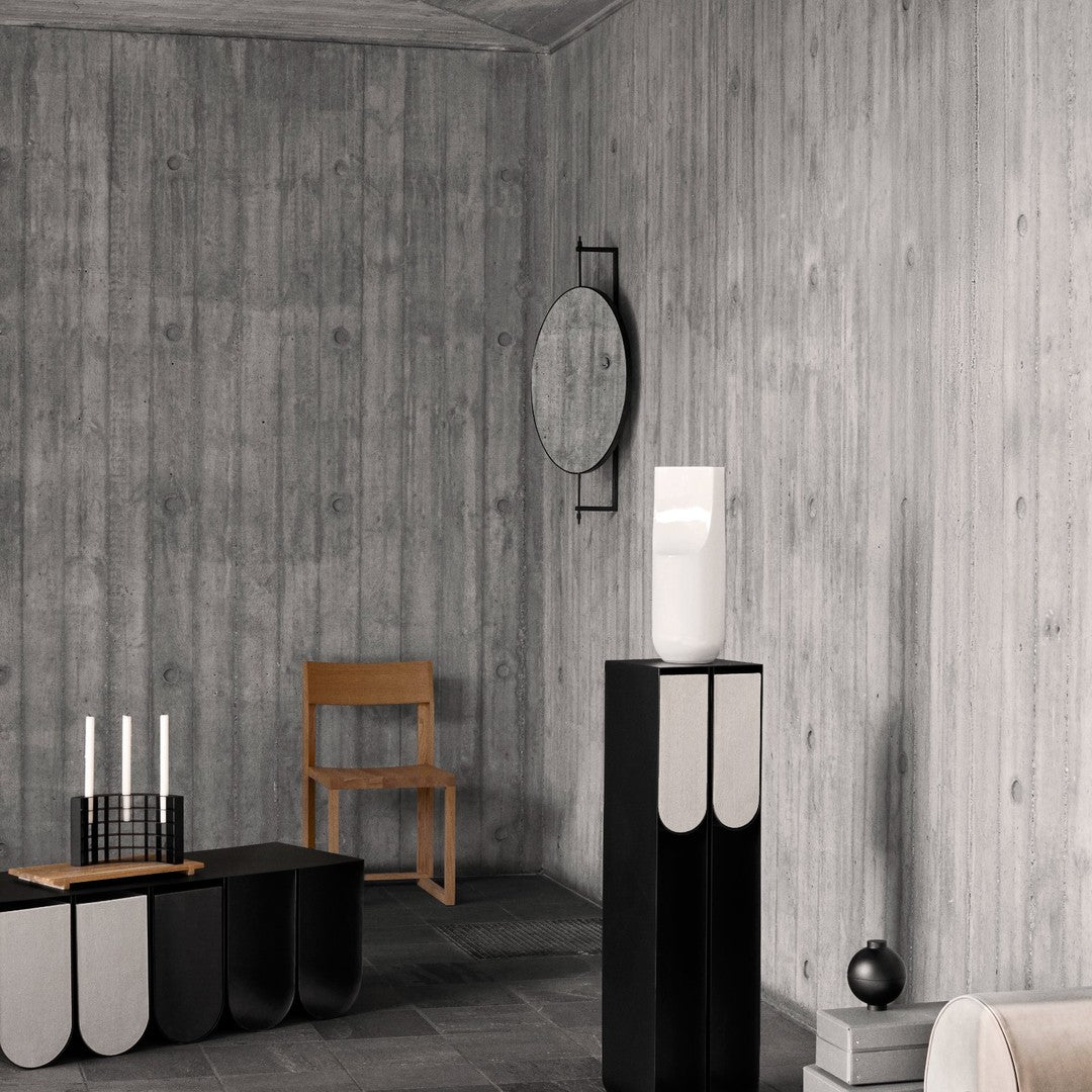 Modern decor featuring a gray wood wall, black and white furniture with curved patterns, and minimalist design elements.