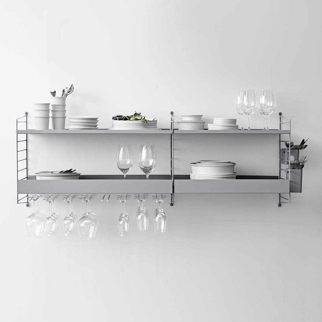 Modern gray wall shelf with sleek shelves, arranged plates, glassware, and minimalist design for elegant decor.