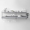 Modern gray wall shelf with sleek shelves, arranged plates, glassware, and minimalist design for elegant decor.