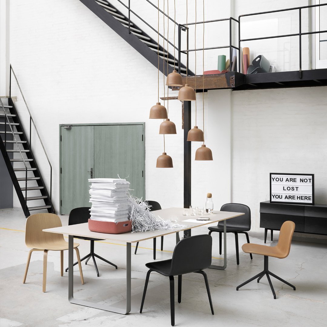 Modern dining room with a neutral palette, featuring black, tan, and earthy brown tones in furniture and decor.
