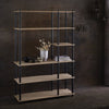 Modern black metal and natural wood bookshelf with clean lines, showcasing warm tones and minimalist design.