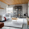 Modern living room featuring a mix of neutral tones, warm wood accents, and geometric patterns in furnishings.
