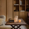 Neutral tones with warm wood, soft textures, and minimalist candle designs create a cozy, inviting atmosphere.