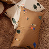 "Two decorative pillows in brown and cream, featuring playful nature-themed patterns and colorful illustrations."
