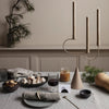 Neutral tones with beige candle holder and soft textures; elegant table setting featuring earth-toned dishes and decor.