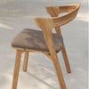 Light oak wooden chair with a grey upholstered seat, featuring a sleek, modern design and smooth contours.