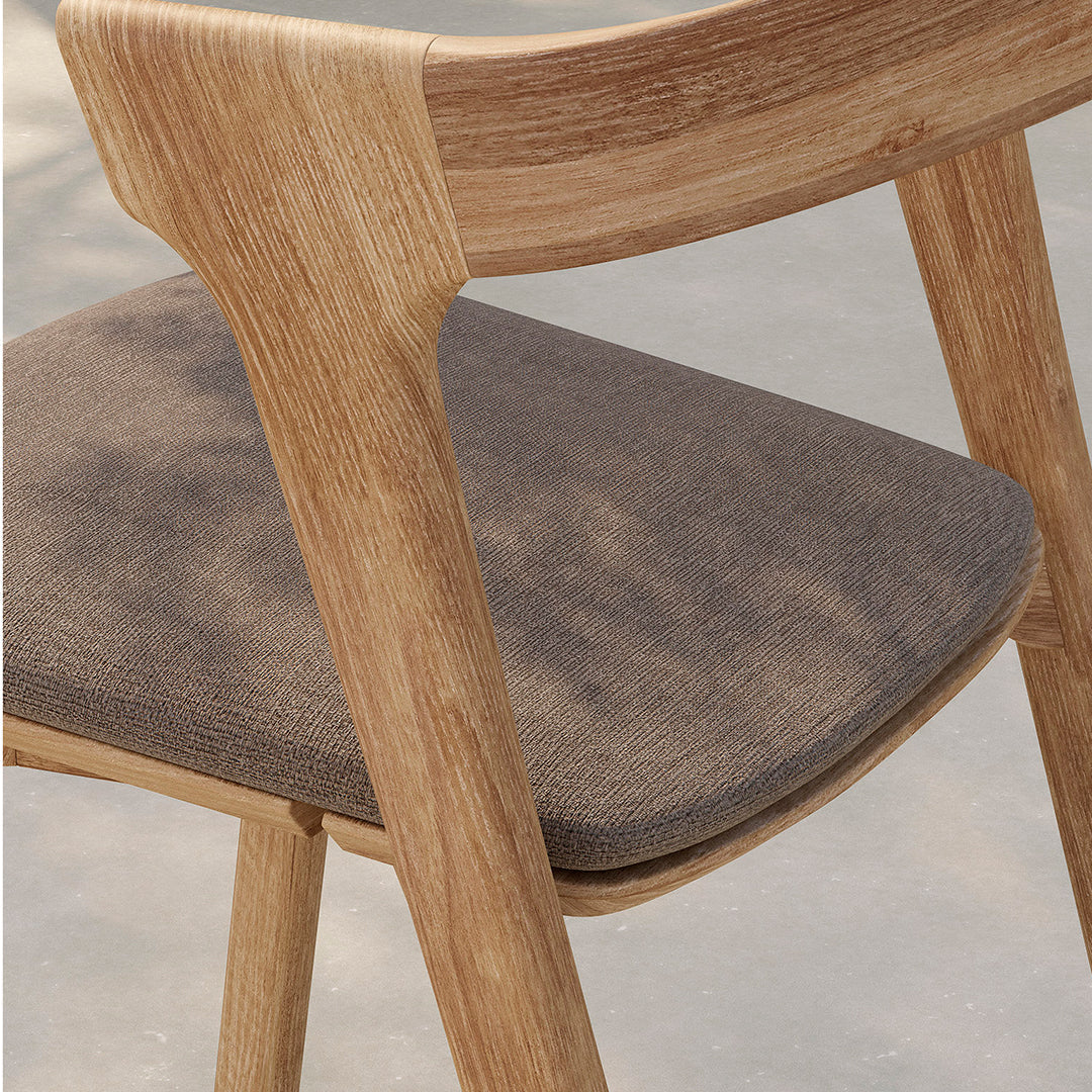 Light wood chair with a smooth grain and soft gray fabric seat, combining natural tones and textures.