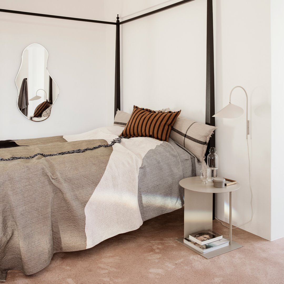 Cozy bed with earthy tones, featuring striped and geometric patterns in warm beige, gray, and deep orange.