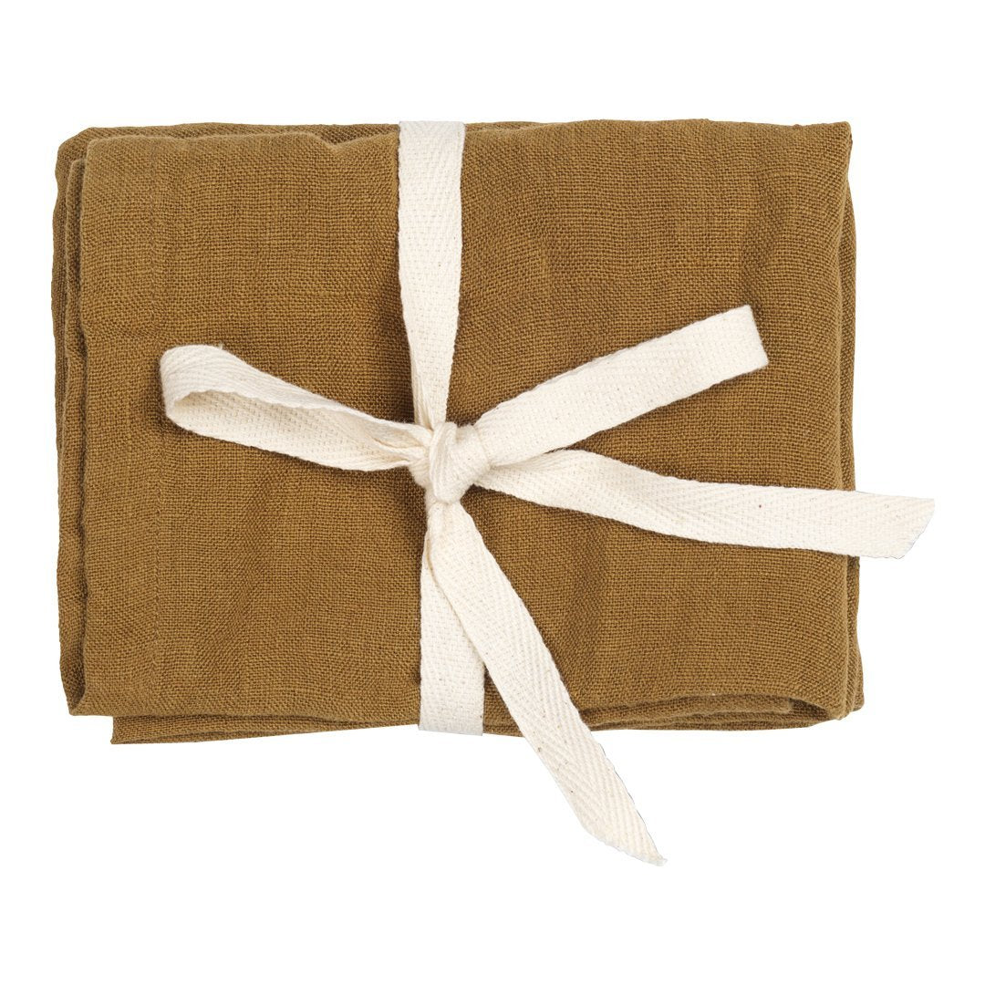 Brown linen napkin set wrapped with a white ribbon, showcasing a solid, earthy color perfect for rustic decor.
