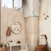 "Neutral earthy tones with a light blue lamp, warm beige walls, and woven textures create a cozy, inviting atmosphere."