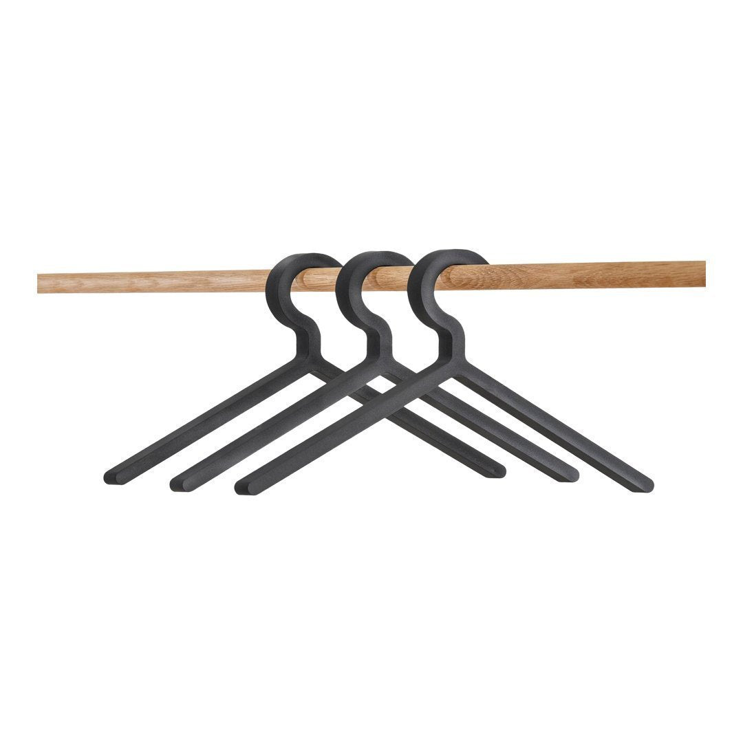 Black plastic hangers on a wooden rod, featuring a sleek, minimalist design. Perfect for organized closets.