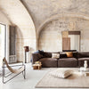 Brown sectional sofa with earthy tones, beige geometric patterns, and a light neutral rug for a modern, chic look.