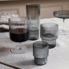 Set of ribbed glassware in smoky gray tones, featuring various shapes and sizes. Elegant, modern design for any table.