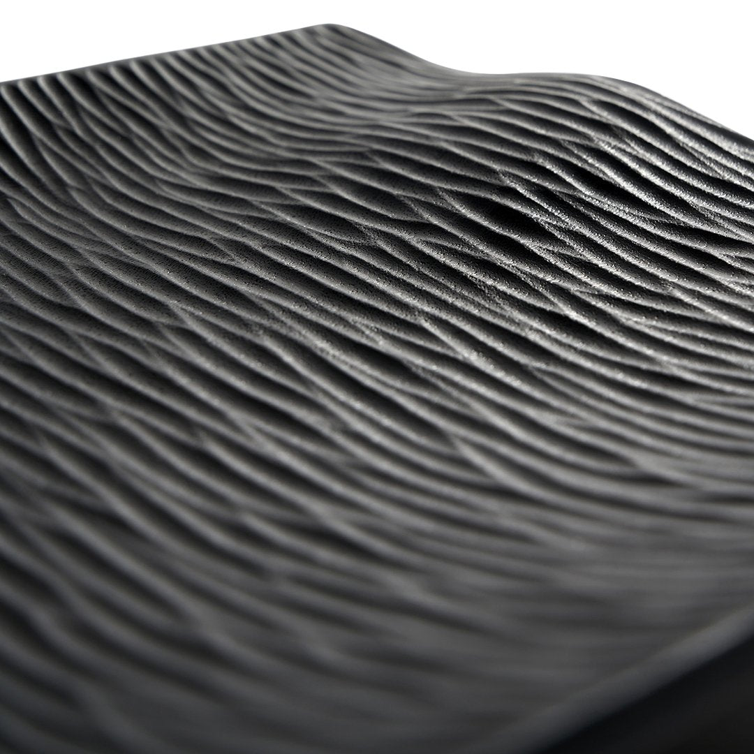 Black textured surface with wavy grooves, creating a dynamic pattern and rich visual depth. Ideal for stylish decor.