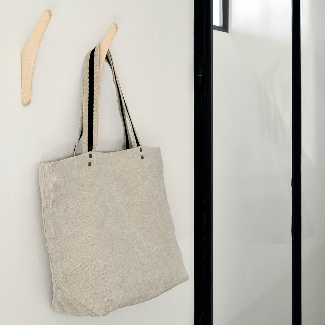 Light gray tote bag with black and cream striped handles, modern minimalist design.