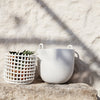White textured planter and grid-patterned pot, showcasing minimalistic design against a natural backdrop.