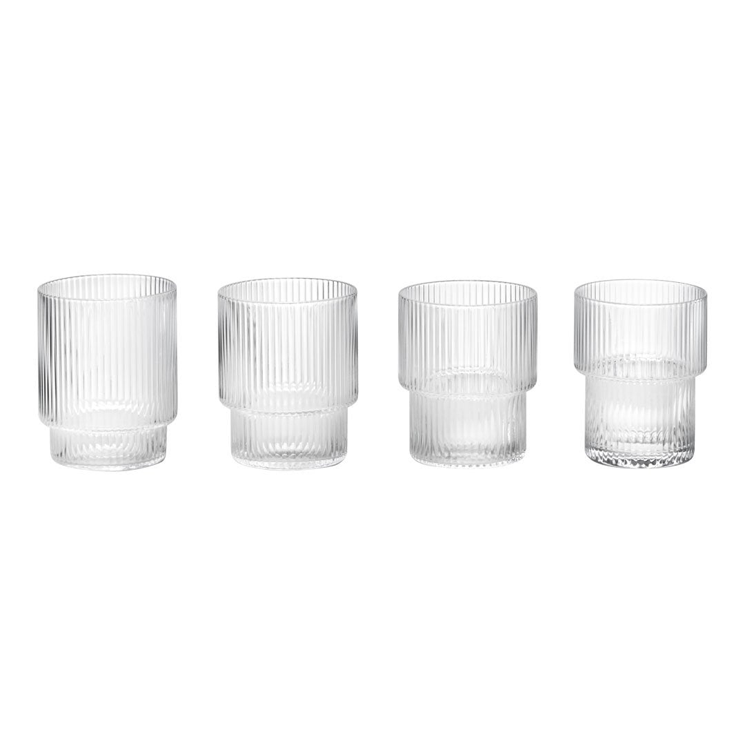 Set of four clear glass tumblers featuring vertical ribbed texture and varying heights. Perfect for modern table settings.