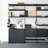 Modern black shelving unit with an industrial design, featuring sleek lines, geometric patterns, and subtle textures.