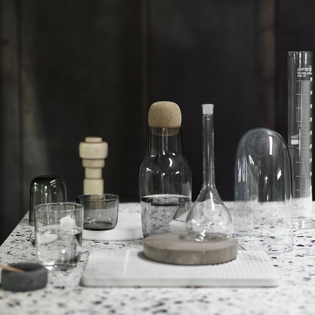 "Clear glassware with cork accents on a speckled stone countertop in a modern setting."