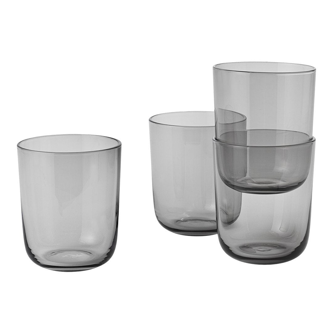 Set of four smoky gray glass cups in varying heights and shapes, showcasing a modern, minimalist design.