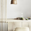 Light wood textures with a soft beige lamp, green glassware, and earthy tones create a modern, minimalist aesthetic.