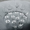 Set of crystal clear wine glasses with elegant shapes, displayed on a textured gray wooden surface.