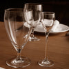 Clear glassware set featuring three elegant designs: a large goblet, medium glass, and a delicate shot glass.