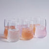 "Set of six glasses showcasing varying pastel shades of pink and clear, perfect for beverages and decorative settings."