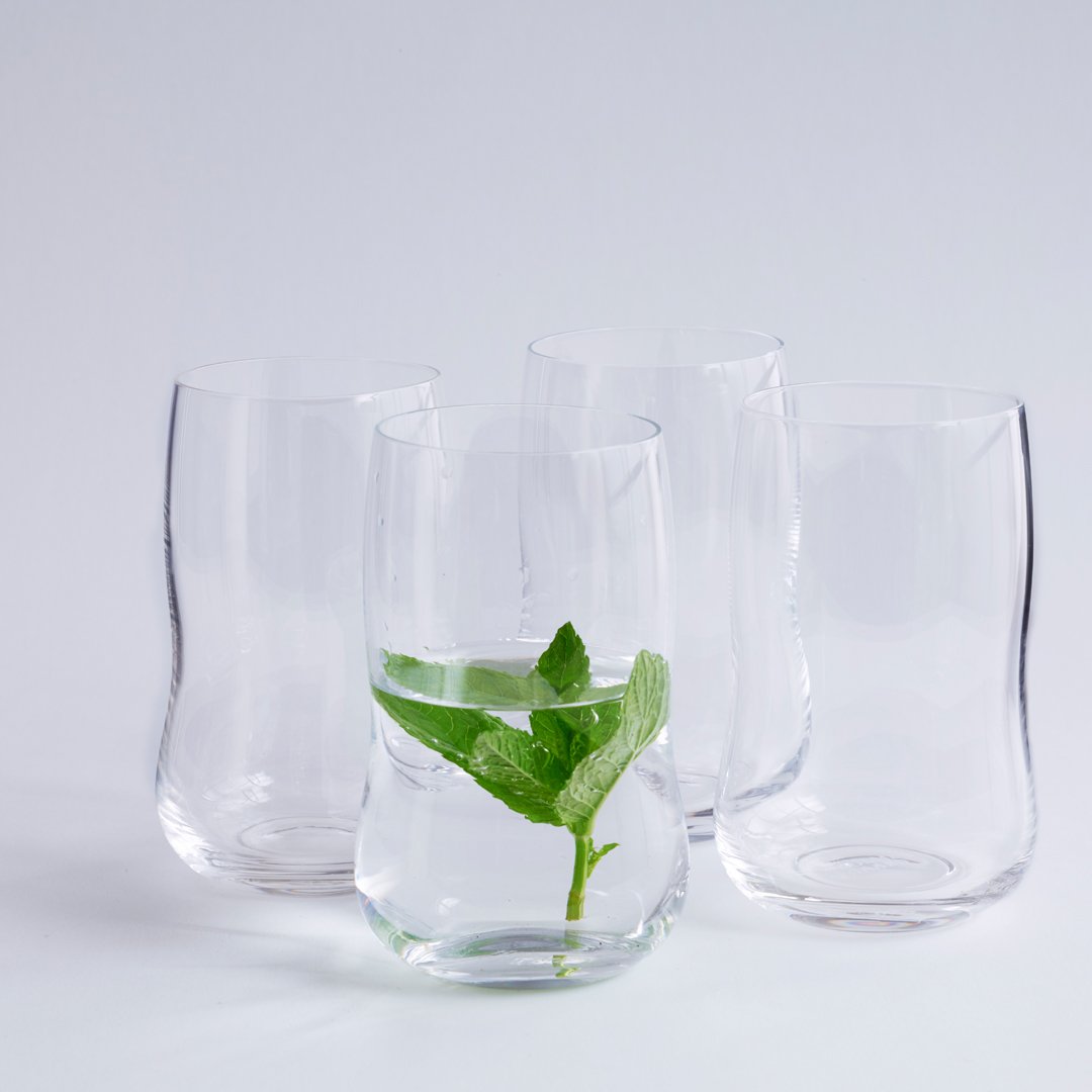 Clear glass tumblers with a modern wavy design, showcasing fresh mint in water. Perfect for elegant dining.