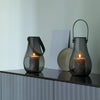 Sleek black glass lanterns with minimalistic designs, featuring soft curves and a modern aesthetic.