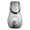 Smoke-gray glass lantern with a sleek black handle, showcasing a white candle inside a circular cutout.