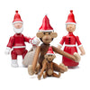 "Wooden holiday figurines in red and white, featuring Santa and playful monkeys in festive hats, vibrant colors."
