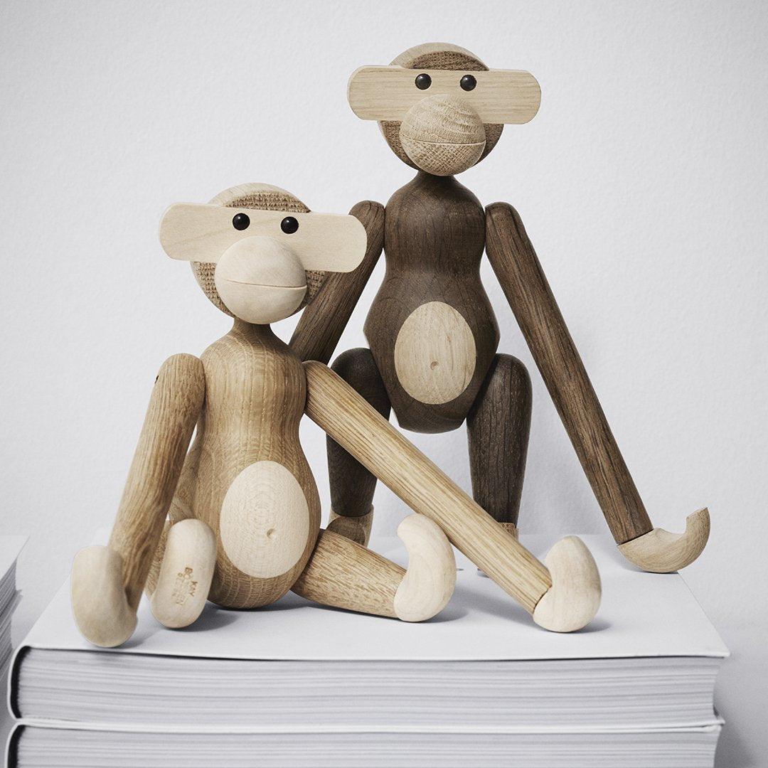 Wooden monkey figurines in natural beige and brown hues, featuring smooth finishes and minimalist designs.