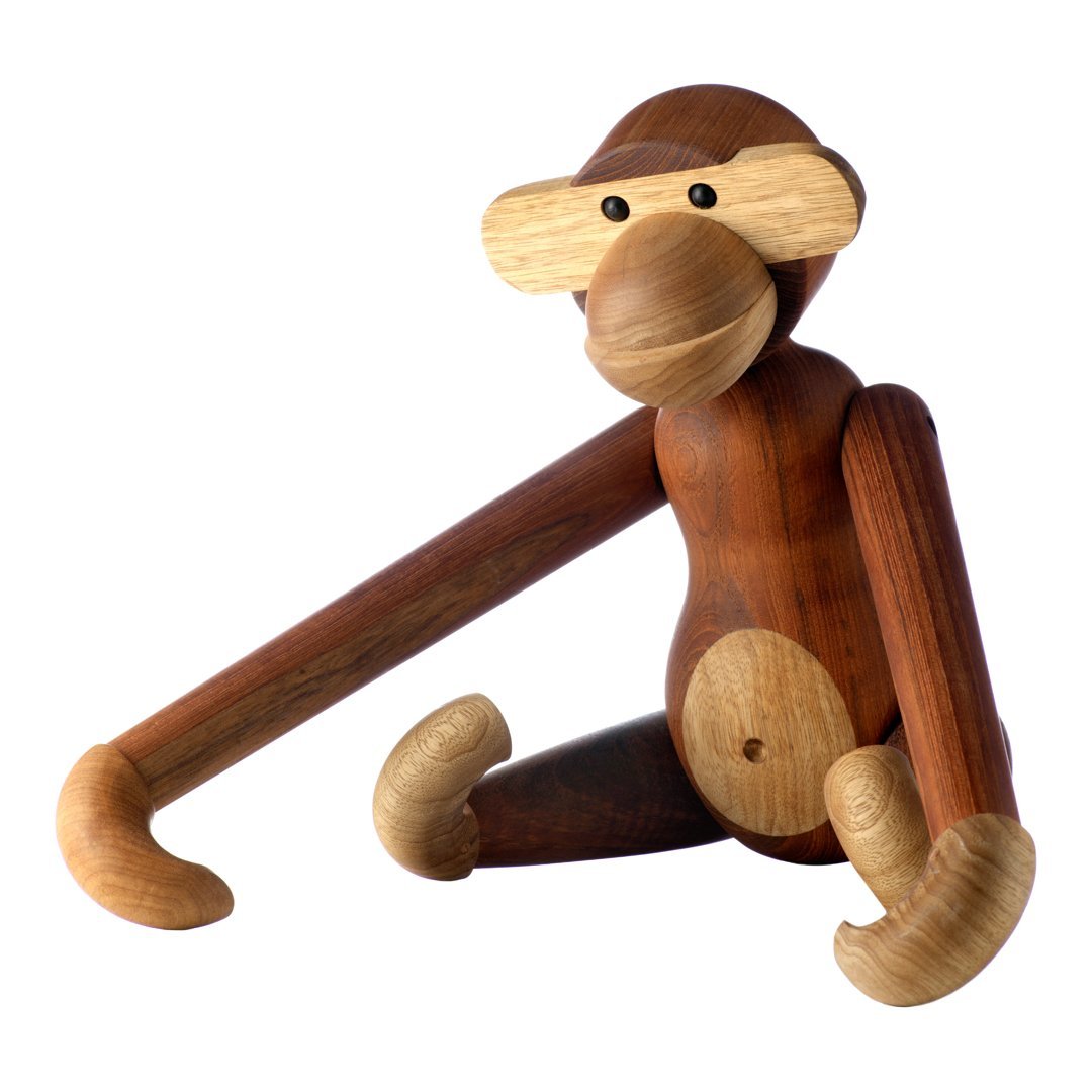 Wooden monkey figurine in brown and beige tones with smooth, rounded shapes and playful design.
