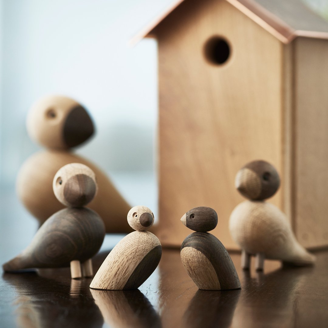 Wooden bird figurines in natural tones with contrast, featuring smooth shapes and a charming textured wooden birdhouse.