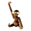 Wooden monkey figurine with rich brown hues, light tan accents, and smooth textures. Playful design with articulated limbs.