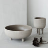 Gray ceramic bowls with ribbed patterns, featuring a matte finish and rounded shapes, styled elegantly in a minimalist setting.