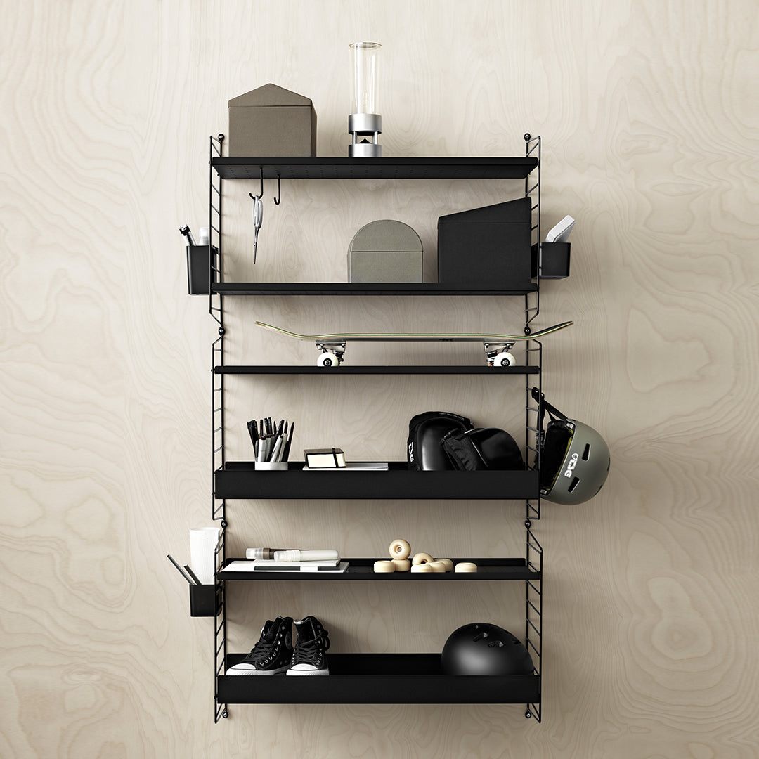 Black shelving unit with multiple levels, featuring minimalist geometric shapes and clean lines against a light wood wall.