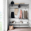 Gray shelving unit with a minimalist design, featuring light-toned clothing and accessories in pastel colors.