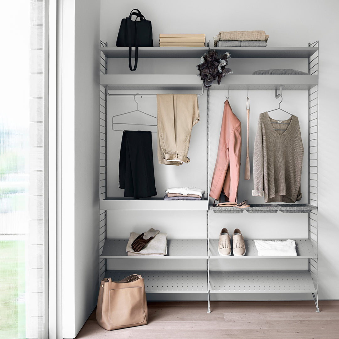 "Minimalist gray shelving with neutral-toned clothing and accessories, featuring soft pastel patterns."