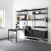 "Modern black metal shelving unit with a minimalist desk and grey floor, featuring clean lines and geometric patterns."