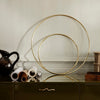 "Gold circular decorative accents against a neutral wall, surrounded by brown and cream rolled paper prints."