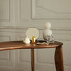 Elegant wooden table with neutral tones, creamy white accessories, and smooth, minimalist patterns against a soft backdrop.