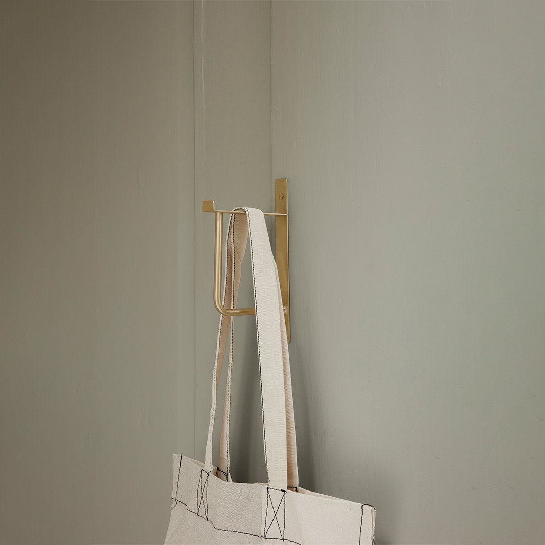 White tote bag with minimalist design, featuring light and neutral tones against a soft gray background.