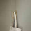 White tote bag with minimalist design, featuring light and neutral tones against a soft gray background.