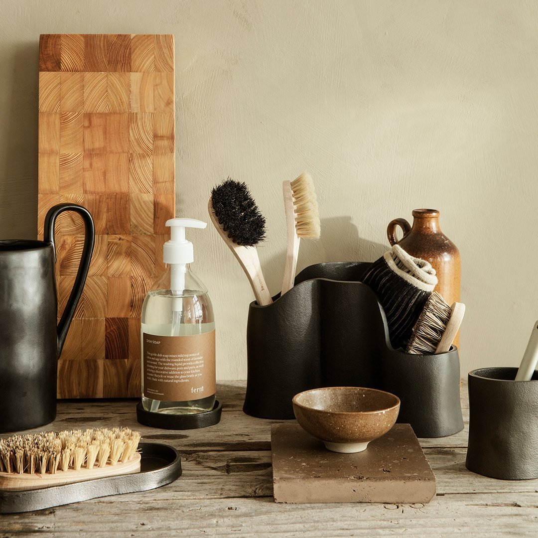 Elegant earthy tones with black ceramic textures and natural wood patterns create a minimalist kitchen aesthetic.