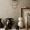 "Collection of earthy tones and unique patterns in vases and decor, featuring dark brown, white, and neutral hues."