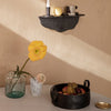 Black wall shelf with smooth edges, yellow flower vase, marble accents, and earthy fruit bowl in soft, neutral tones.
