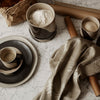Modern kitchen setup featuring earthy tones, black and beige patterns, and a soft, floral print fabric.